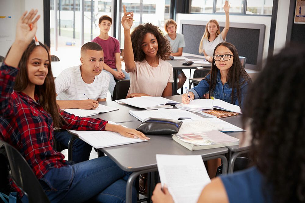 A group of students sitting at a table with papers.