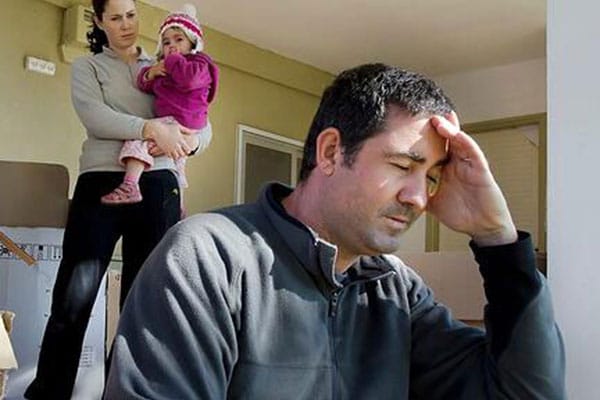 A man sitting in front of a woman holding her baby.