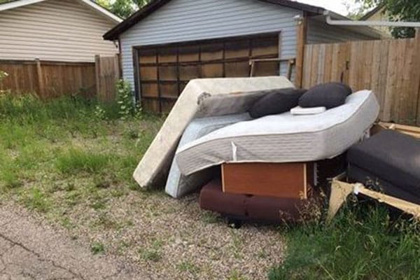 A mattress and bed frame in the grass.