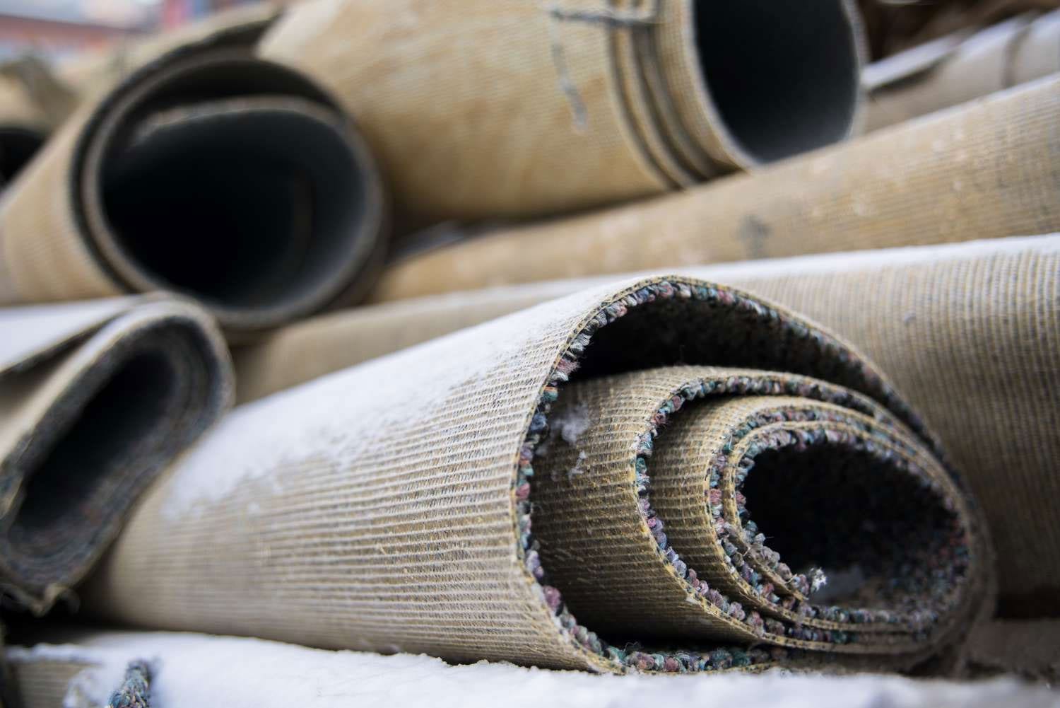 A pile of carpet rolls sitting on top of each other.