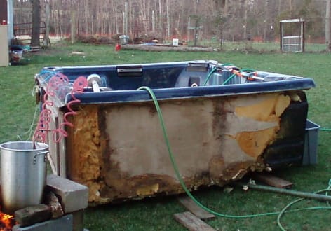 A blue and white tub sitting in the grass.